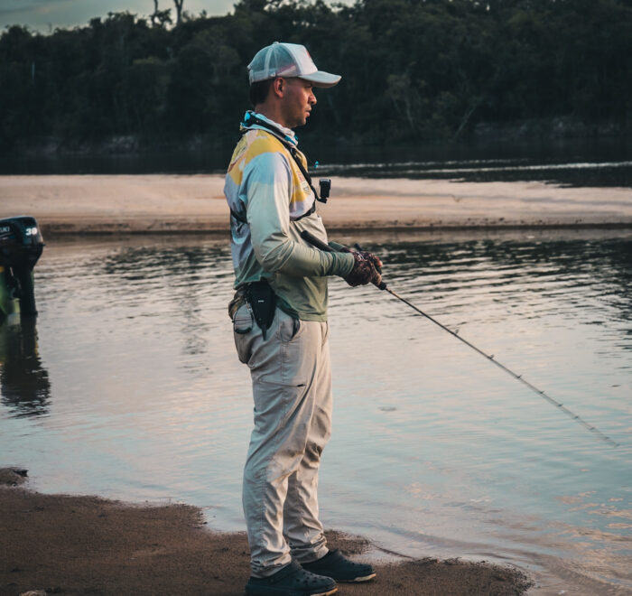 Angler fishing on the edge of a peaceful river beach in Colombia. Explore untouched fishing spots—book your luxury fishing trip today!