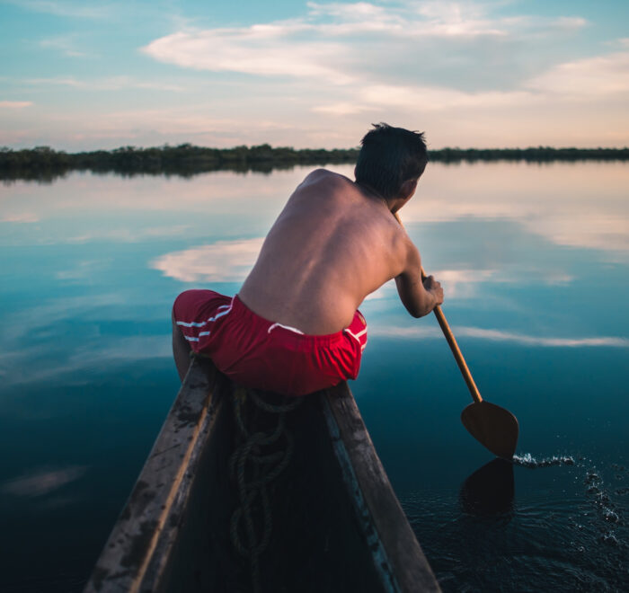 Local indigenous paddling through an exclusive fishing lagoon in Colombia. Immerse yourself in nature and culture—plan your fly fishing trip today!